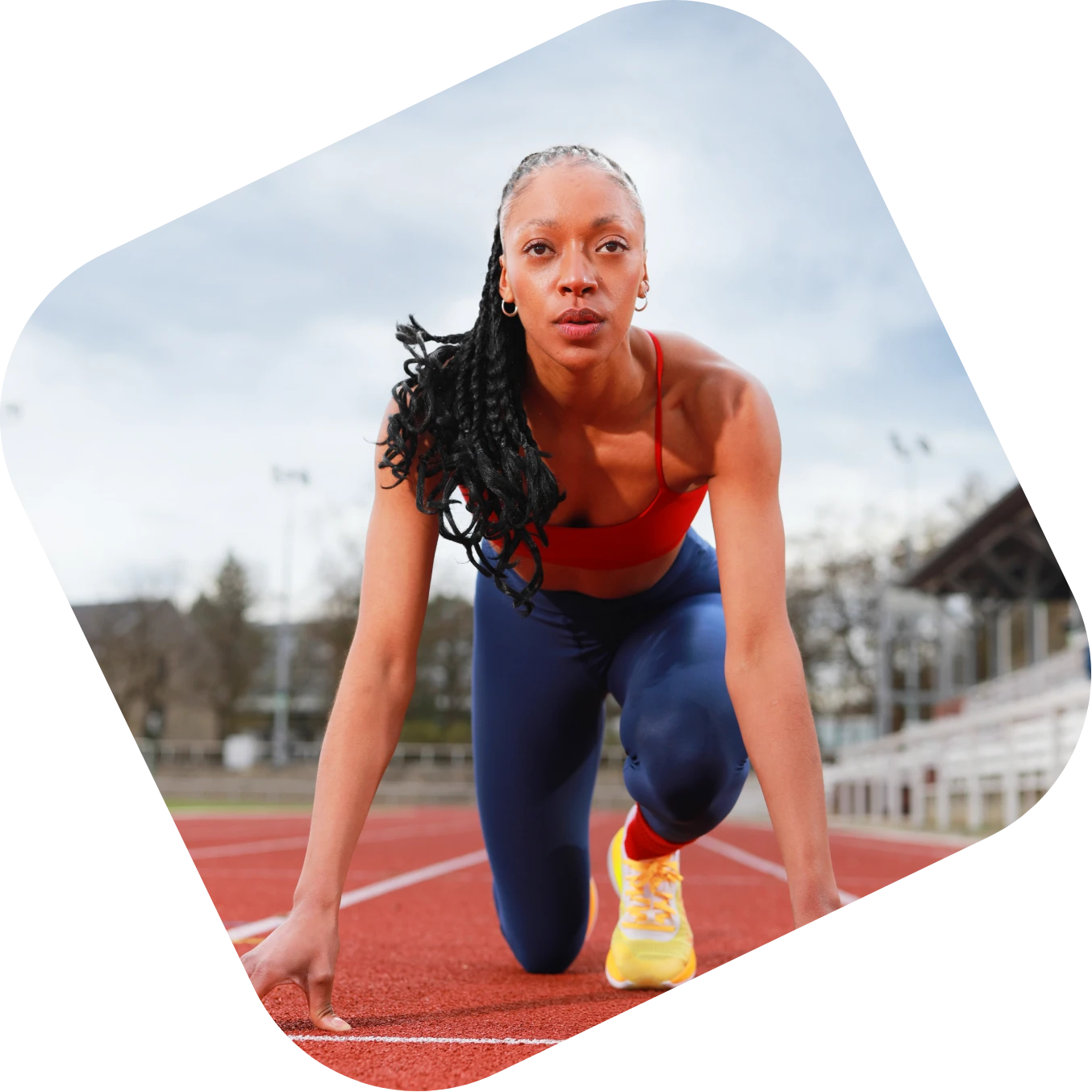 Frau in Startposition auf roter Laufbahn – Forever Young Bewegung